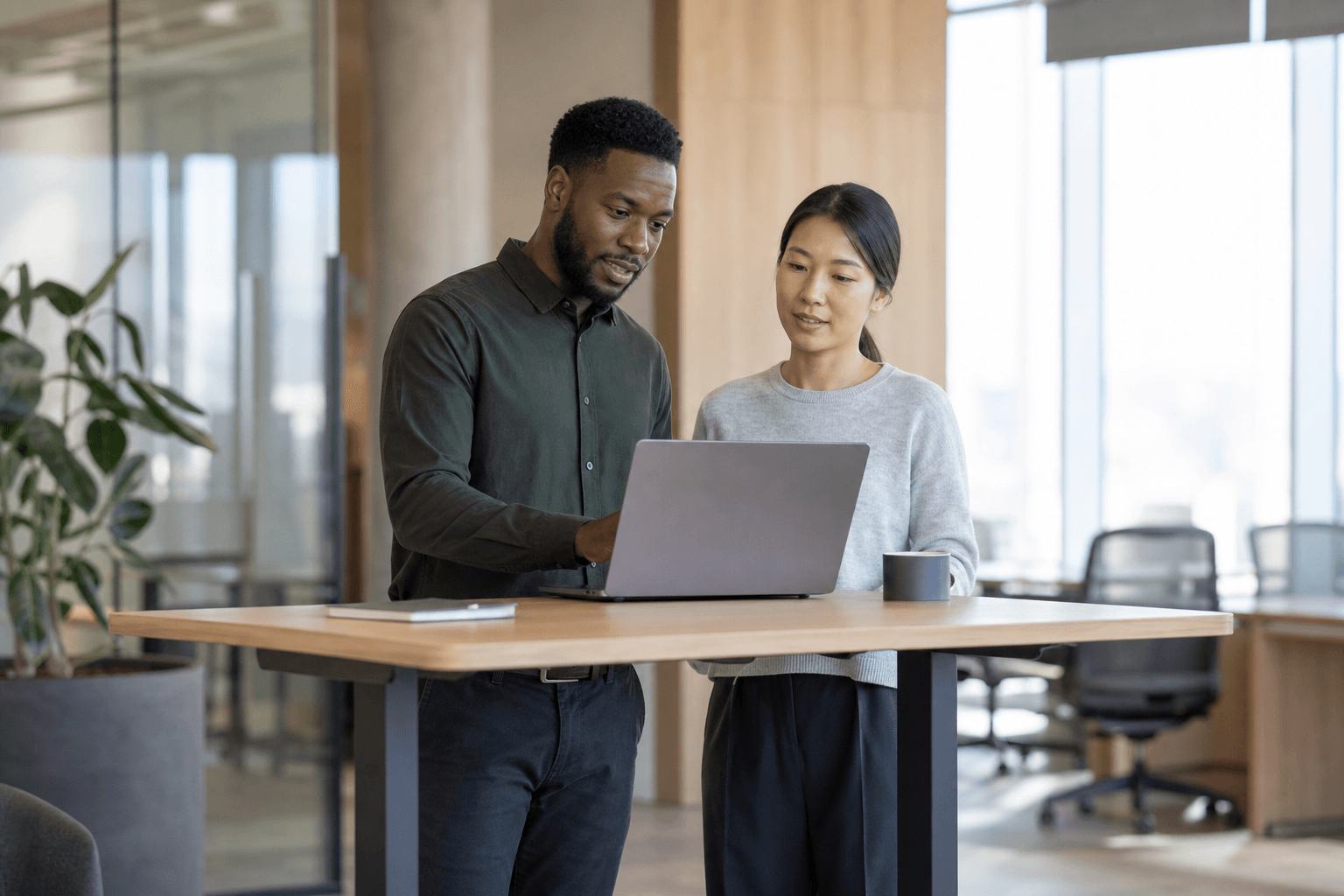 Two colleagues reviewing a task's progress together at a standing desk